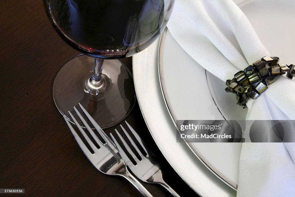 Elegant table setting with napkin ring and a glass of wine