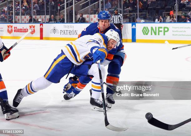 Matt Martin of the New York Islanders slows up Zemgus Girgensons of the Buffalo Sabres during the first period at UBS Arena on October 14, 2023 in...