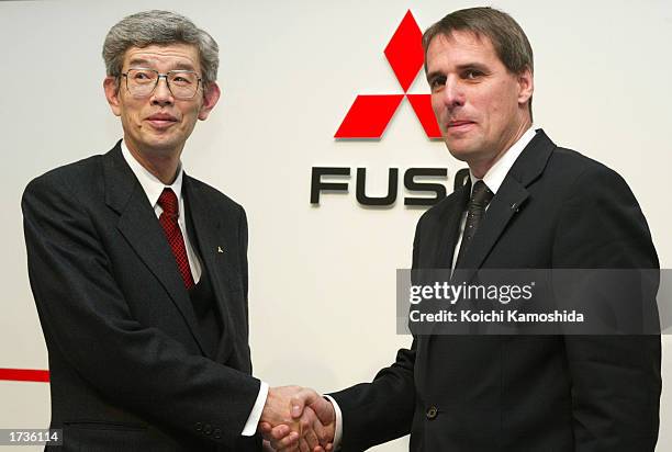 Wilfried Porth and Takashi Usami, Chairman of the Board, shake hands at a news conference announcing Porth as the CEO of the new Mitsubishi Fuso...