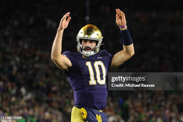 Sam Hartman of the Notre Dame Fighting Irish celebrates a touchdown by Audric Estime against the USC Trojans during the first half at Notre Dame...