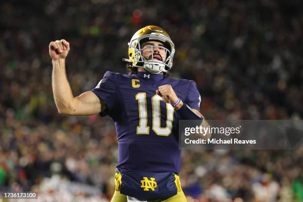 Sam Hartman of the Notre Dame Fighting Irish celebrates a touchdown by Audric Estime against the USC Trojans during the first half at Notre Dame...