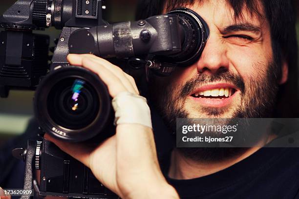 close-up of videographer filming with bandage on hand - filmteam stockfoto's en -beelden