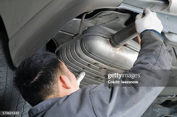 auto mechanic removing muffler - exhaust pipe stock pictures, royalty-free photos & images