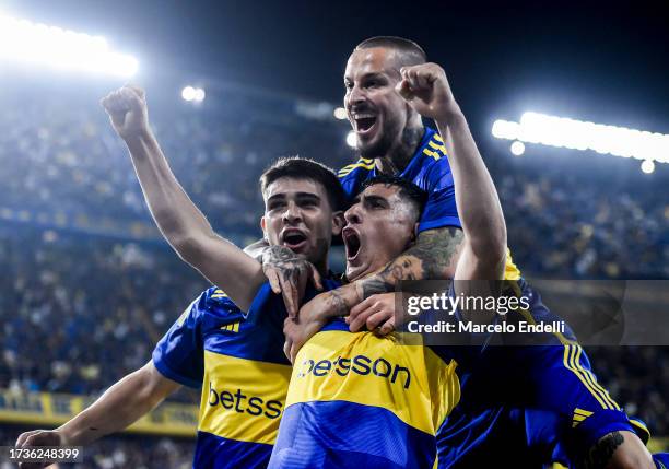 Miguel Merentiel of Boca Juniors celebrates with teammates Vicente Taborda and Dario Benedetto after scoring the team's second goal during a match...