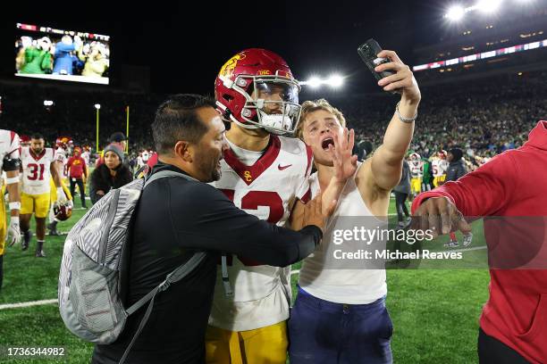 Fan takes a selfie with Caleb Williams of the USC Trojans after the Notre Dame Fighting Irish defeated the USC Trojans and rushed the field at Notre...