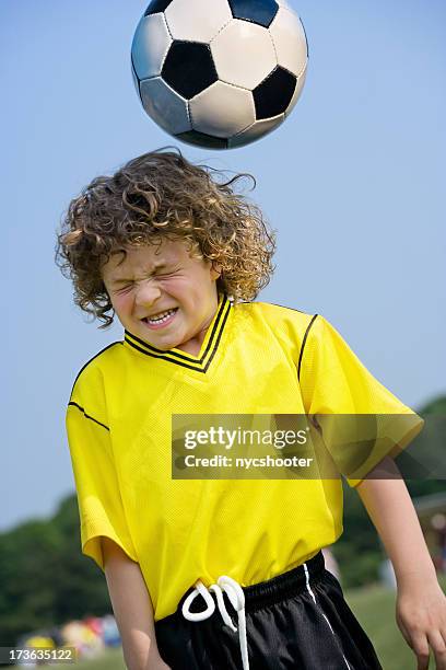 boy dirección pelota de fútbol - head injury fotografías e imágenes de stock