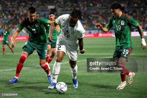 Antoine Semenyo of Ghana attempts to dribble as he is guarded by César Montes and Jorge Sanchez of México during the first half of their match at...