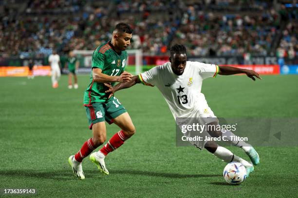 Joseph Paintsil of Ghana dribbles as he is guarded by Orbelin Pineda of México during the first half of their match at Bank of America Stadium on...