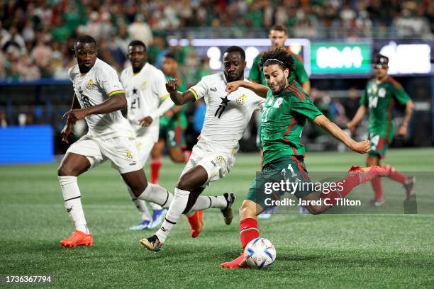 César Huerta of México attempts a shot against Elisha Owusu of Ghana during the second half of their match at Bank of America Stadium on October 14,...