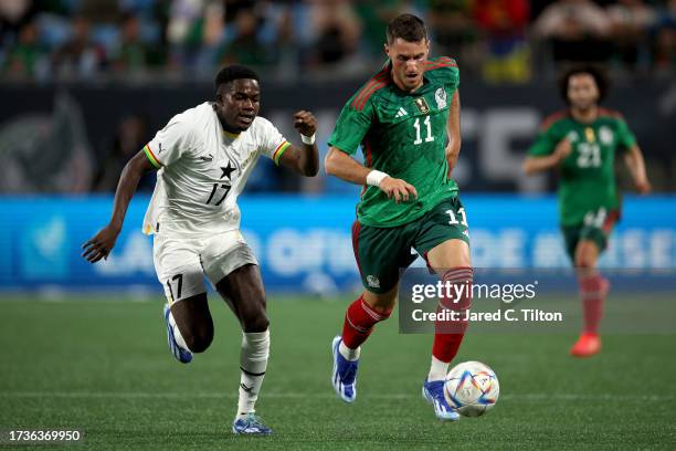 Santiago Gimenez of México dribbles while defended by Ernest Appiah of Ghana during the second half of their match at Bank of America Stadium on...