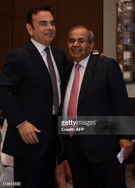 And chairman of Renault-Nissan, Carlos Ghosn and co-chairman of Hinduja Group, G.P. Hinduja greet each other during the launch of Hinduja Group's...