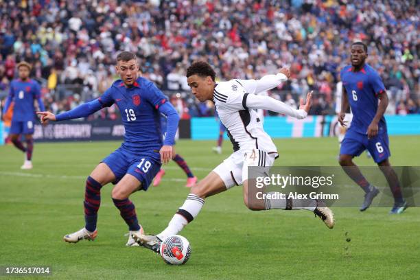 Jamal Musiala of Germany is challenged by Joe Scally of United States during the international friendly match between Germany and United States at...