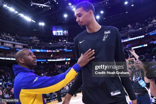 Chris Paul of the Golden State Warriors and Victor Wembanyama of the San Antonio Spurs embrace after the game on October 20, 2023 at Chase Center in...