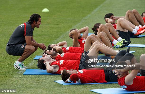 Head coach Diego Pablo Simeone of Atletico de Madrid jokes with his players during a training session with the club at the Los Angeles de San Rafael...