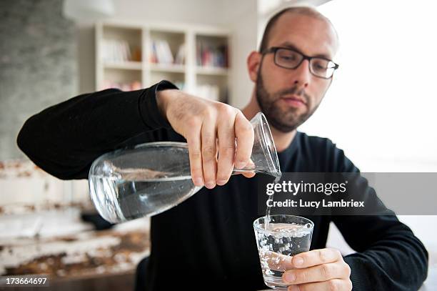 pouring tapwater from a pitcher - voll stock-fotos und bilder