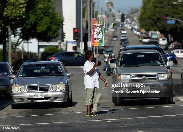 Protestors hold signs at an intersection near Leimert Park during a demonstration against the acquittal of George Zimmerman in the shooting death of...