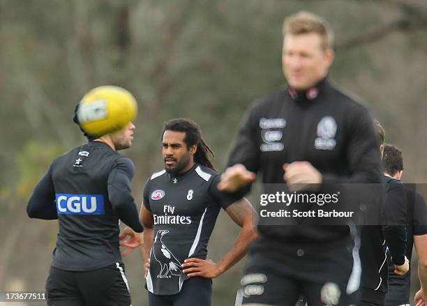 Harry O'Brien of the Magpies looks on as Nathan Buckley the coach of the Magpies passes the ball during a Collingwood Magpies AFL training session at...