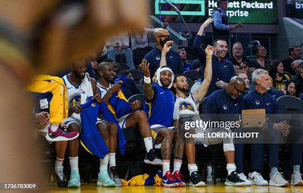 Golden State Warriors' US guard Stephen Curry gestures from the bench with teammates guard Gary Payton II, guard Chris Paul and Canadian forward...