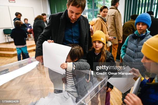 Child casts her father ballot during Poland's Parliamentary elections on October 15, 2023 in Warsaw, Poland. Poles are voting today to decide whether...