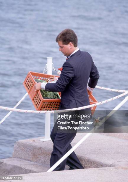 Michael Fawcett, valet to HRH Prince Charles , carrying a plastic crate of Highgrove vegetables to the Royal Yacht Britannia on the quayside at...