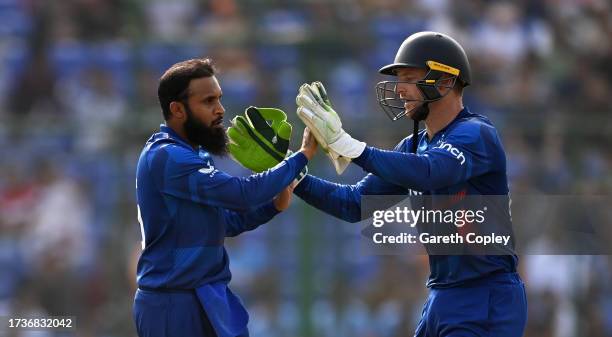 Adil Rashid of England celebrates the wicket of Ibrahim Zadran of Afghanistan with team mate Jos Buttler during the ICC Men's Cricket World Cup India...