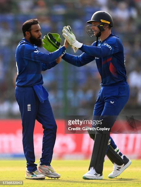 Adil Rashid of England celebrates the wicket of Ibrahim Zadran of Afghanistan with team mate Jos Buttler during the ICC Men's Cricket World Cup India...
