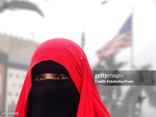 Islamic woman wearing a red burqa when a group of demonstrators gather in front of the United States of America Embassy in Lima, in support of the...