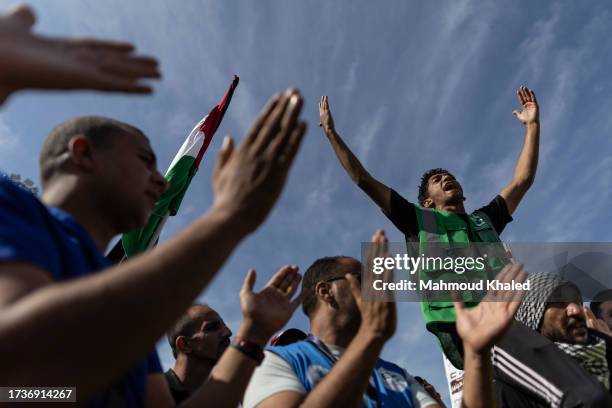 Volunteers and NGOs staff celebrate the aid convoy trucks crossing the Rafah border from the Egyptian side on October 21, 2023 in North Sinai, Egypt....