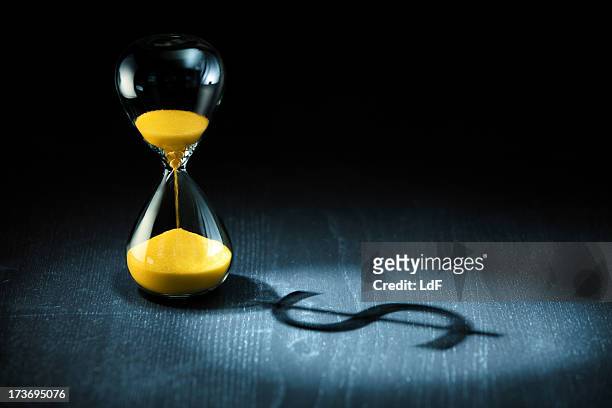hourglass and dollar shadow - timglas bildbanksfoton och bilder