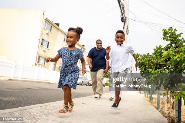 afroamerikanische familie läuft zum spaß in rockaway beach - dreiviertel vorderansicht stock-fotos und bilder