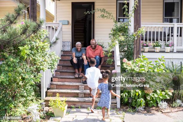 happy black seniors welcoming visiting grandchildren - veranda stock pictures, royalty-free photos & images