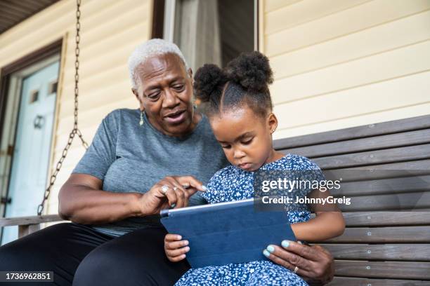 young black girl learning how to use digital tablet - swing chair stock pictures, royalty-free photos & images