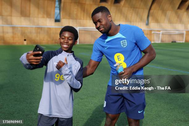 Marc Guehi of England poses for a photo with a Tottenham Hotspur Youth Academy Player at Spurs Lodge on October 14, 2023 in London, England.