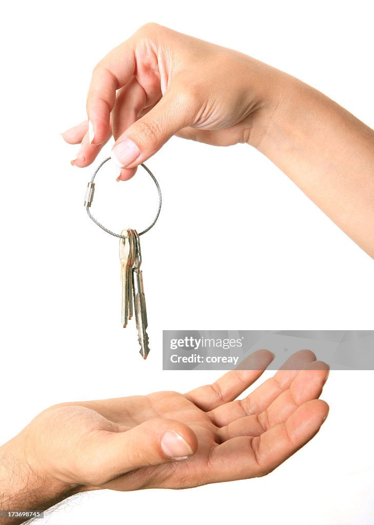 Hand holding keys over an open hand on white background