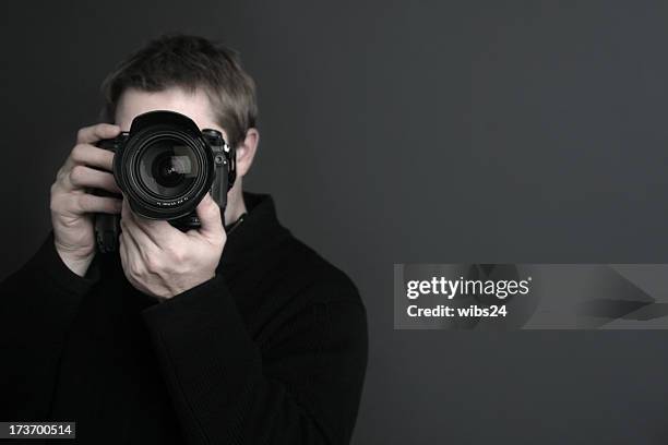 portrait of a photographer with camera in front of his face - photo shoot studio bildbanksfoton och bilder