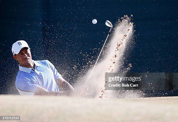 Tiger Woods of the United States chips out of a bunker ahead of the 142nd Open Championship at Muirfield on July 17, 2013 in Gullane, Scotland.