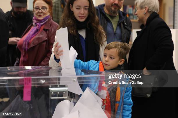 Little boy drops his mother's ballot into the urn in Polish parliamentary elections on October 15, 2023 in Warsaw, Poland. Poles are voting today to...