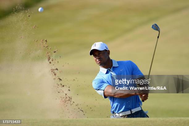 Tiger Woods of the United States hits from a bunker on the 11th hole ahead of the 142nd Open Championship at Muirfield on July 17, 2013 in Gullane,...