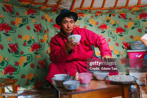 mongolian man drinking tradition milk tea inside yurt - independent mongolia stockfoto's en -beelden