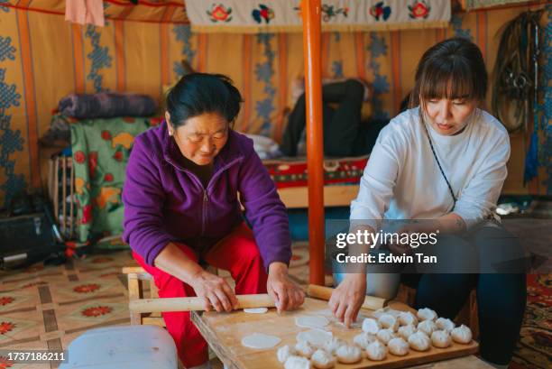 mongolische nomadenfrauen bereiten traditionelle teigtaschen zu, buuz in ger, traditionelles jurtenzelt - mongolischer abstammung stock-fotos und bilder