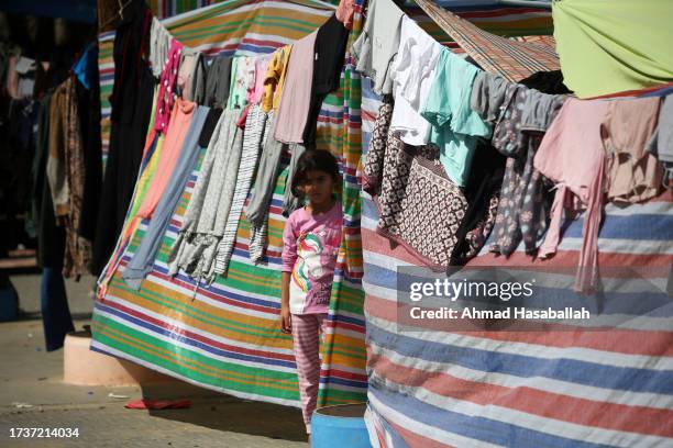 Displaced Palestinian citizens gather at the UNRWA school in Khan Yunis, after evacuating their homes that were damaged by Israeli airstrikes on...