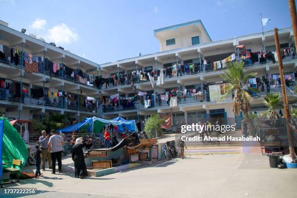 Displaced Palestinian citizens gather at the UNRWA school in Khan Yunis, after evacuating their homes that were damaged by Israeli airstrikes on...