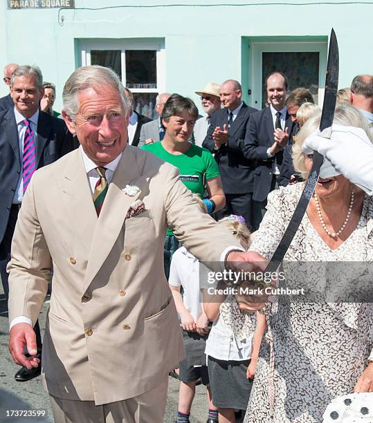 Prince Charles, Prince of Wales and Camilla, Duchess of Cornwall, with the sword she used to cut the birthday cake given to her on her 66th birthday,...