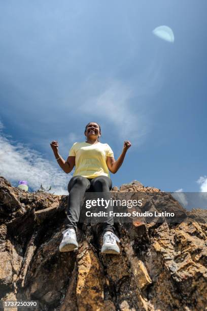 mid adult woman celebrating on a mountain peak - colombia mountains stock pictures, royalty-free photos & images