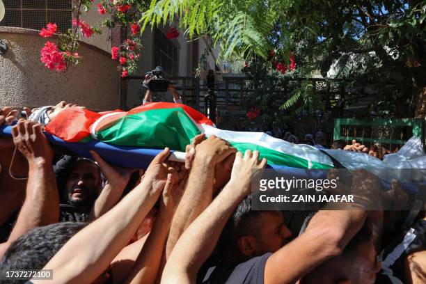 Mourners carry the body of 17-year-old Oday Mansour, a day after he was killed during clashes with Israeli soldiers at a military checkpoint near...