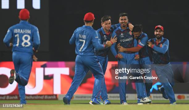 Mujeeb ur Rahman of Afghanistan celebrates the wicket of Harry Brook of England during the ICC Men's Cricket World Cup India 2023 between England and...