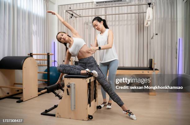 woman with pilates trainer practising pilates - yoga ball work stock pictures, royalty-free photos & images