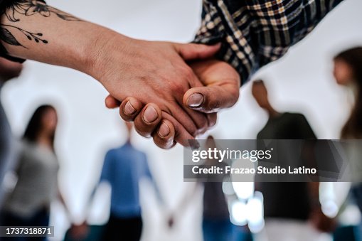 Primo piano di pazienti che si tengono per mano sostenendosi a vicenda durante la sessione di terapia di gruppo Primo piano di pazienti che si tengono per mano sostenendosi a vicenda durante la sessione di terapia di gruppo