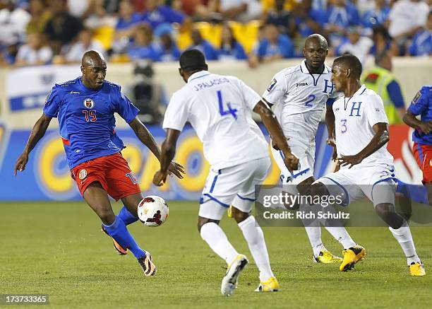 Midfielder Yves Hadley Desmarets of Haiti in action against defenders Johnny Palacios, Osman Chavez and Brayan Beckeles of Honduras during a 2013...