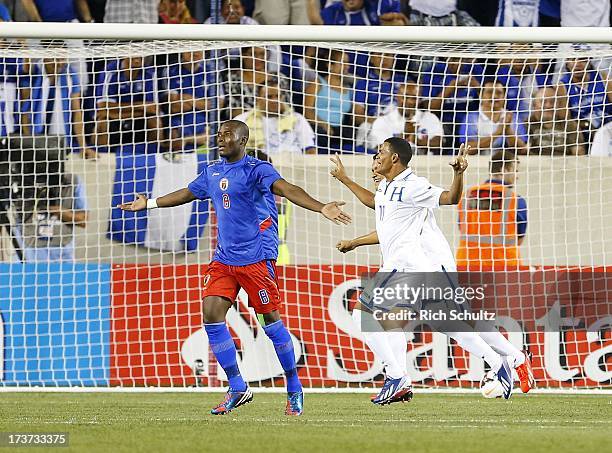 Midfielder Rony Martinez of Honduras celebrates his goal as defender Judelin Aveska Haiti questions the call during a 2013 CONCACAF Gold Cup soccer...